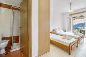 two beds in a room with a shower and a toilet at Panorama studios 3 in Póndi +18 photos