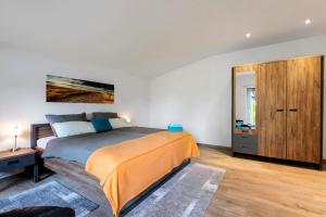 a bedroom with a bed and a wooden cabinet at Ferienwohnung Offenbütteler Moor in Osterrade