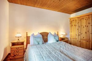 a bedroom with a bed with two night stands and two lamps at Ferienwohnung an den Bergen in Unterwössen