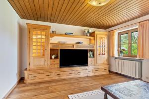 a living room with a flat screen tv in a cabinet at Ferienwohnung an den Bergen in Unterwössen