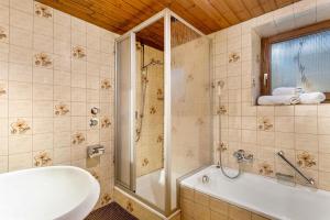 a bathroom with a shower and a tub and a sink at Ferienwohnung an den Bergen in Unterwössen +13 photos