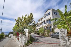 a white building with a stone wall next to a street at Panorama studios 3 in Póndi