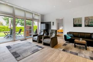 a living room with a leather couch and chairs at Ferienwohnung Offenbütteler Moor in Osterrade