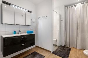 a white bathroom with a sink and a shower at Ferienwohnung Offenbütteler Moor in Osterrade +21 photos