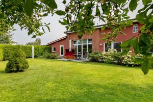 a red brick house with a yard at Ferienwohnung Offenbütteler Moor in Osterrade