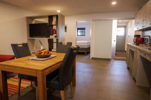 a kitchen and dining room with a table with a bowl of fruit at Ferienwohnung Alter Kuhstall in Neuenstein +7 photos
