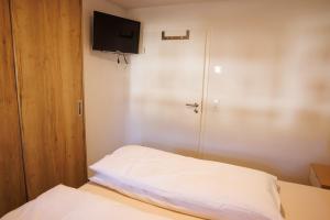 a small bedroom with a bed and a flat screen tv at Ferienwohnung Alter Kuhstall in Neuenstein