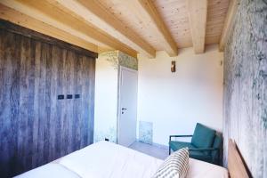 a bedroom with a bed and a green chair at Bellagio - Baita treeb Tivano in Bellagio