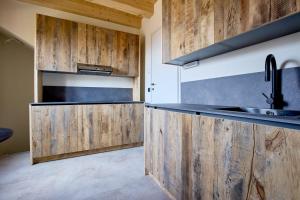 a kitchen with wooden cabinets and a sink at Bellagio - Baita treeb Tivano in Bellagio