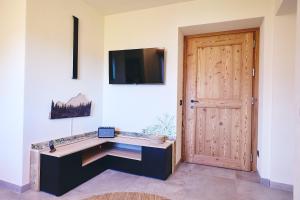 a room with a desk with a television and a door at Bellagio - Baita treeb Tivano in Bellagio