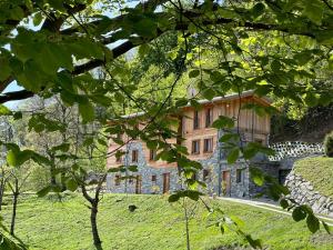 a large stone building on a hill with trees at Bellagio - Baita treeb Tivano in Bellagio