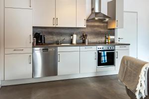 a kitchen with white cabinets and a stainless steel dishwasher at Apfelkiste in Meßstetten