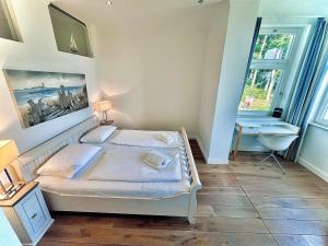 a bedroom with a bed and a desk and a sink at Appartement Baltic Pearl in Ostseebad Sellin +17 photos