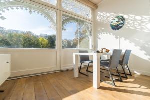 a dining room with a table and chairs and windows at Appartement Baltic Pearl in Ostseebad Sellin