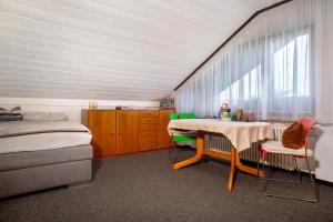 a bedroom with a bed and a table and chairs at Apfelstübchen in Friedrichshafen +14 photos