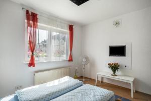 a bedroom with a bed and a window with red curtains at Ferienwohnung Schläfer in Kappel-Grafenhausen