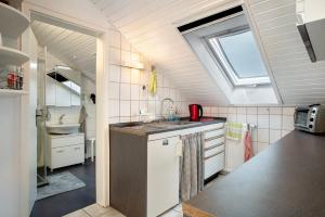 a small kitchen with a sink and a window at Apfelstübchen in Friedrichshafen