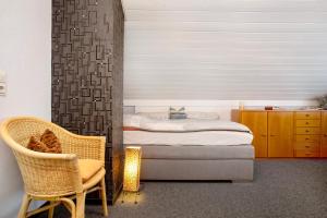 a bedroom with a bed and a chair at Apfelstübchen in Friedrichshafen