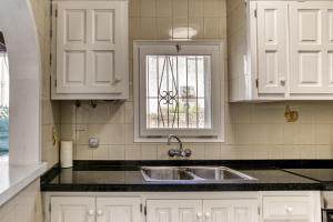 a kitchen with white cabinets and a sink and a window at Casa de Riells in L'Escala +20 photos
