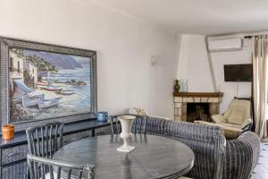 a living room with a table and a painting on the wall at Casa de Riells in L'Escala