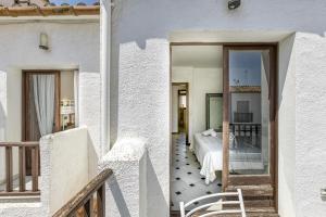 a white house with a bedroom and a balcony at Casa de Riells in L'Escala