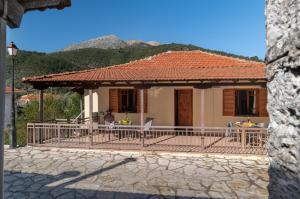 a house with a table and chairs in front of it at Krinos apartment 1 in Kharadhiátika