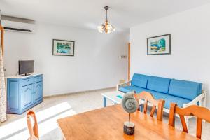 a living room with a blue couch and a table at Apartamentos Karin 1ºb in Santanyi