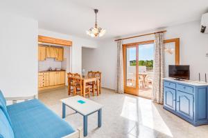 a living room with a blue couch and a table at Apartamentos Karin 1ºb in Santanyi