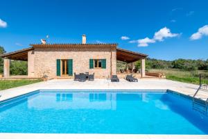 a villa with a pool in front of a house at Finca can Mandai in Son Carrió