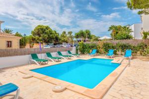a swimming pool with chaise lounge chairs and a swimming poolvisorvisor at Apartamentos Karin 1ºb in Santanyi