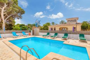 a swimming pool with chairs and a house at Apartamentos Karin 1ºb in Santanyi