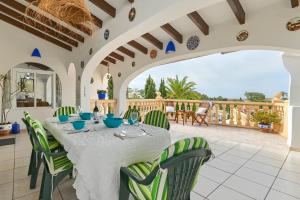 a dining room with a table and green chairs at Dulce in Benissa