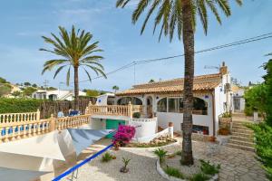 a villa with palm trees and a house at Dulce in Benissa
