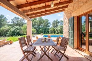 a patio with a table and chairs and a pool at Finca can Mandai in Son Carrió