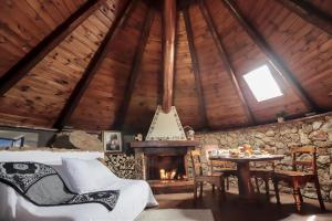 a room with a fireplace and a table in a cabin at Pinnetta Sarda in Codrongianos