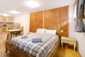 a bedroom with a bed and a table in a kitchen at Premesan 4 in Bormio