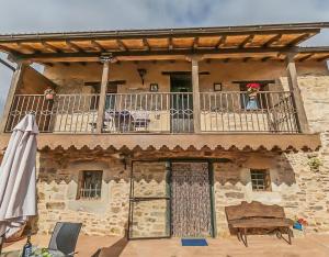 an old stone building with a balcony and an umbrella at Jumaca in Valdespino de Somoza
