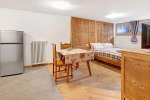 a kitchen with a table and a bed in a room at Premesan 4 in Bormio