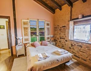 a bedroom with a bed and a stone wall at Jumaca in Valdespino de Somoza