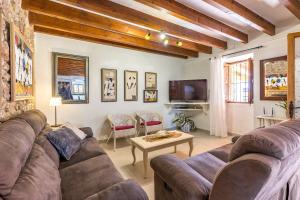 a living room with a couch and a tv at Can Pou Petit in Pollença