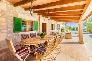 a wooden table and chairs on a patio at Can Pou Petit in Pollença
