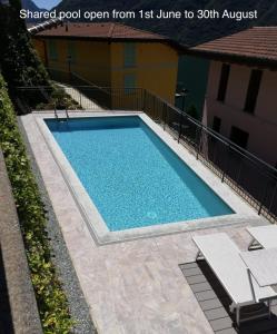 a swimming pool with blue water in a yard at Appartamento 3 Il Tornante in Nesso +15 photos