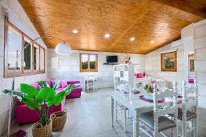 a living room with a table and pink chairs at Biniaco in Muro