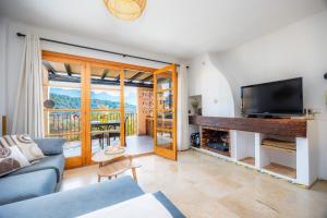 a living room with a couch and a tv at Montemar 33 in Port de Soller