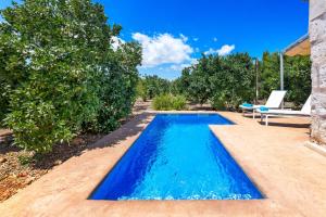 a swimming pool in a backyard with a chair and a table at Biniaco in Muro