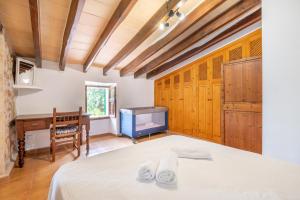 a bedroom with a bed and a desk and a tv at Can Pou Petit in Pollença +34 photos