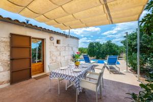 a patio with a table and chairs and a building at Biniaco in Muro
