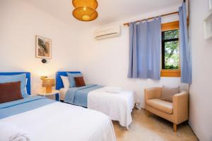 a bedroom with two beds and a chair and a window at Montemar 33 in Port de Soller +31 photos