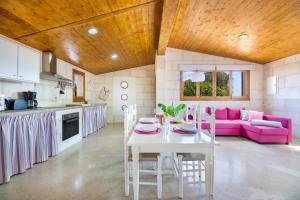 a kitchen and living room with a table and a pink couch at Biniaco in Muro