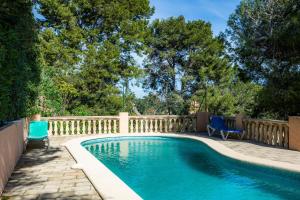a swimming pool with two chairs and a fence at Montemar 33 in Port de Soller